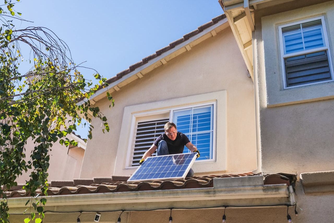 Man with solar panel on the roof